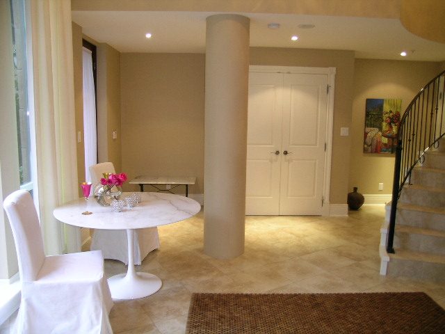 Spacious living room with modern decor, white furniture, and a staircase leading to upper levels. - 202 -1280 Richards Street, Vancouver Downtown