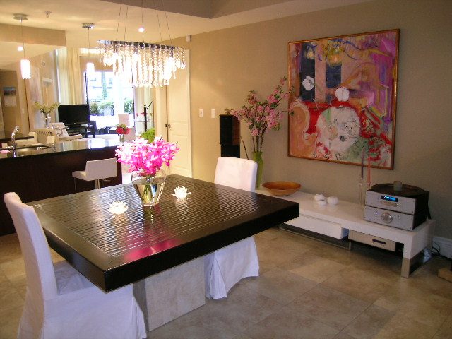 Open dining area with modern chandelier, vibrant artwork, and sleek countertops. - 202 -1280 Richards Street, Vancouver Downtown