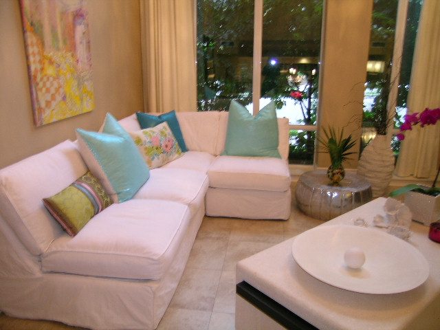 Bright living room with white couches, teal pillows, and a city view. - 202 -1280 Richards Street, Vancouver Downtown