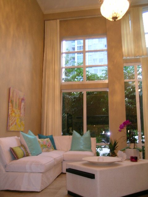 Bright living room with white sectional, large windows, and city view. - 202 -1280 Richards Street, Vancouver Downtown