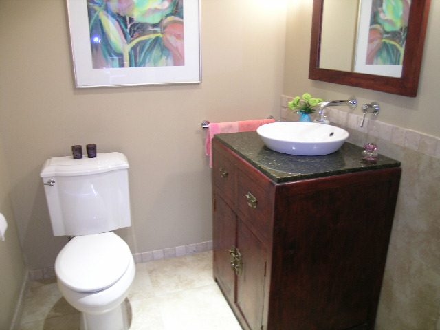 Bathroom with dark wood vanity, marble countertop, and framed floral art. - 202 -1280 Richards Street, Vancouver Downtown
