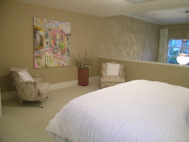 Spacious bedroom with large bed, armchair, and abstract painting. - 202 -1280 Richards Street, Vancouver Downtown