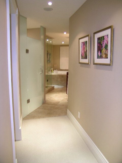 Spacious hallway leading to a modern bathroom with glass shower and artwork on walls. - 202 -1280 Richards Street, Vancouver Downtown