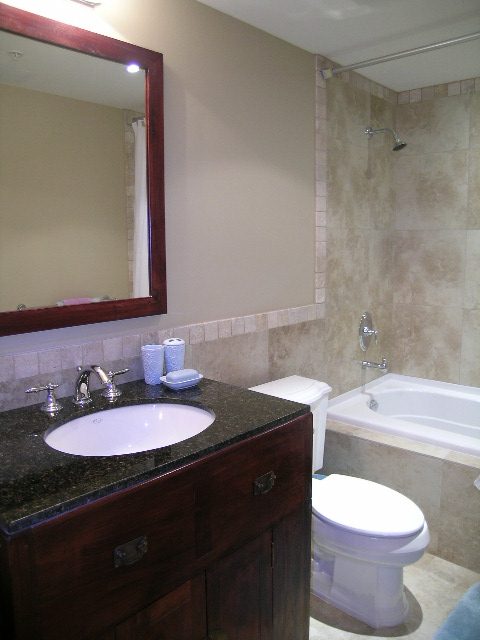 Bathroom with dark marble countertops and wooden vanity. - 202 -1280 Richards Street, Vancouver Downtown