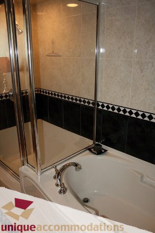 Bathroom with glass shower, black and white tiled accents, modern fixtures. - 2105-1383 Marinaside Crescent, Vancouver Downtown