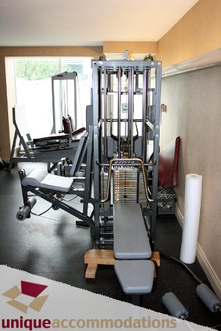 Bright gym with weight machines and a bench, clean and organized. - 2105-1383 Marinaside Crescent, Vancouver Downtown