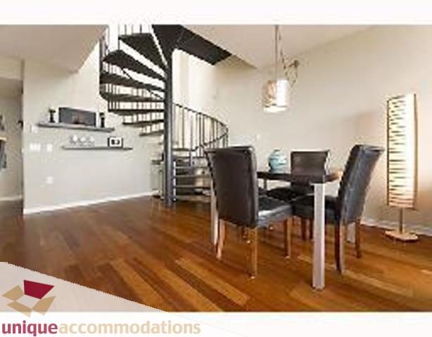 Furnished dining area with spiral staircase, hardwood floors, and modern decor. - 3205 - 1068 Hornby Street, Vancouver Downtown