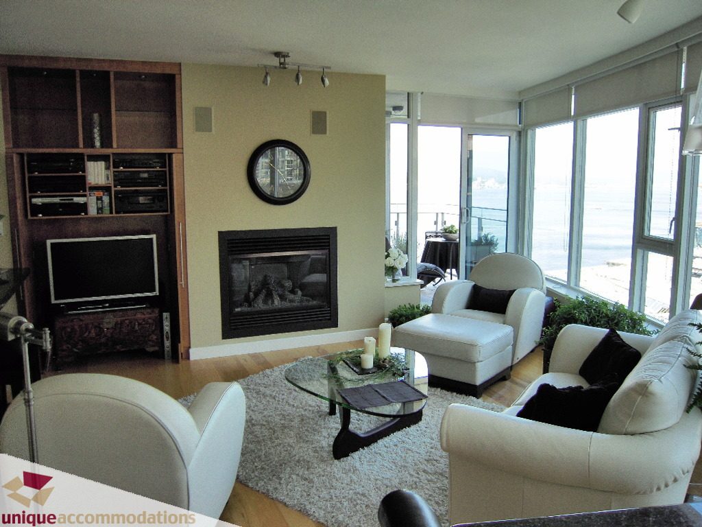 Spacious living room with hardwood floors, large windows, and a cozy fireplace, perfect for downtown Vancouver.