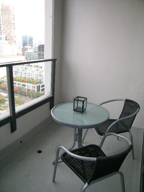 Furnished balcony with glass table, chairs, and city view. - 2217 - 938 Smithe Street, Vancouver Downtown