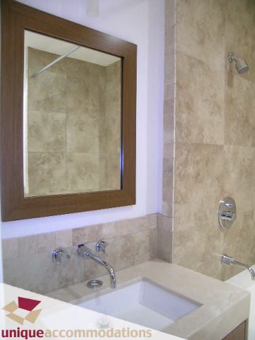Furnished bathroom with modern sink and mirror, beige tiles. - 1501 - 1280 Richards Street, Vancouver Downtown