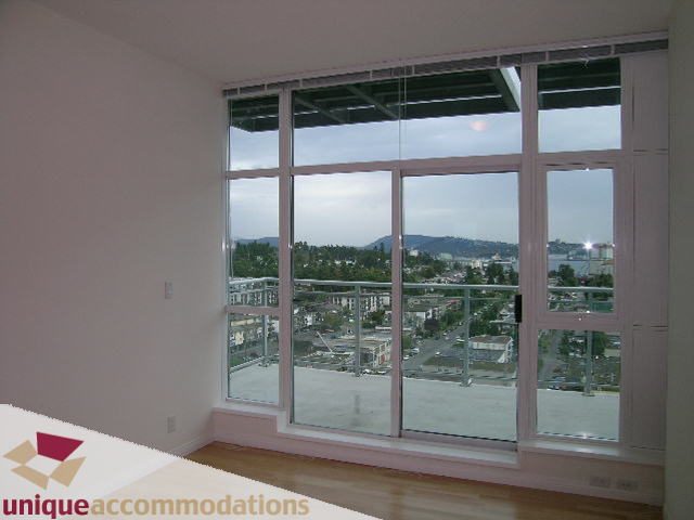 Bright living room with hardwood floors and a stunning city view. - 2301 - 188 E Esplanade, North Vancouver