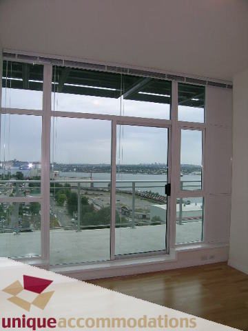 Bright living room with large windows, hardwood floors, and a stunning city view. - 2301 - 188 E Esplanade, North Vancouver