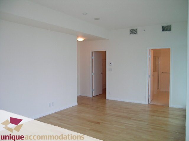 Spacious living room with hardwood floors and large windows. - 2301 - 188 E Esplanade, North Vancouver