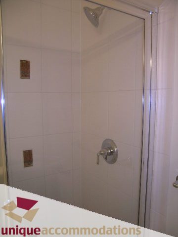 Shower with glass door and wall-mounted faucet. - 2301 - 188 E Esplanade, North Vancouver