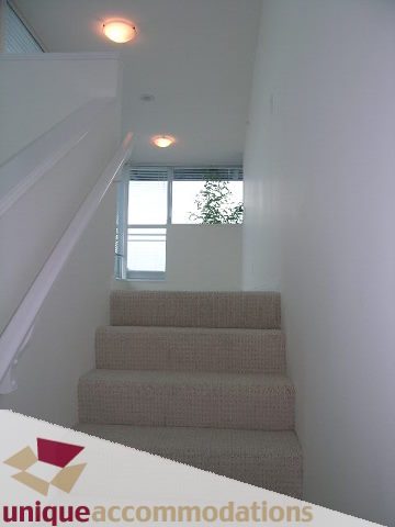 Bright staircase leading to a penthouse with white walls and a modern design. - 2301 - 188 E Esplanade, North Vancouver