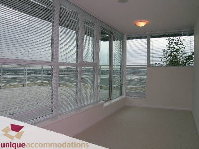 Spacious penthouse living room with floor-to-ceiling windows, city view, and modern decor. - 2301 - 188 E Esplanade, North Vancouver