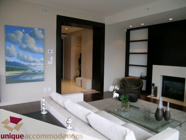 Furnished living room with modern decor, glass coffee table, and large artwork. - 302 - 1169 West Cordova, Vancouver Downtown