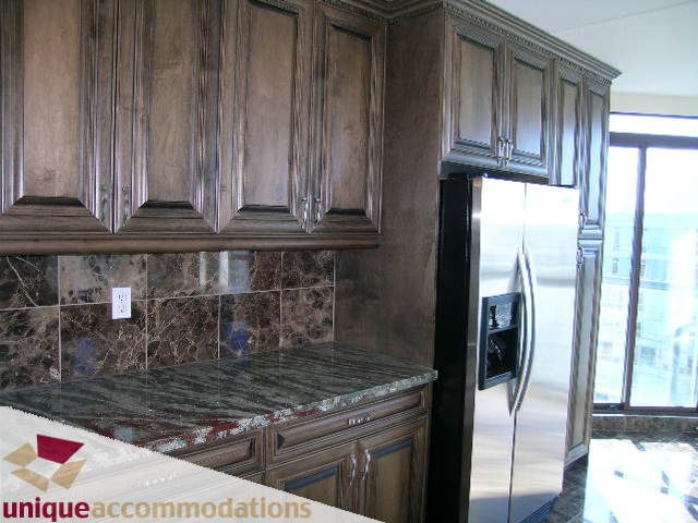 Bright kitchen with dark wood cabinets, granite countertops, and stainless steel appliances. - 2201 - 1415 West Georgia, Vancouver Downtown