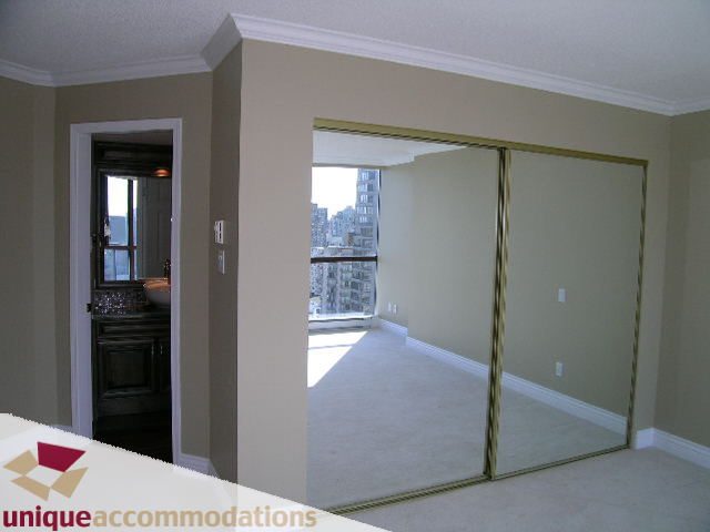Bright living room with large sliding mirror doors, city view, and carpeted floor. - 2201 - 1415 West Georgia, Vancouver Downtown