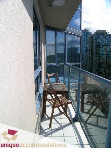 Furnished balcony with city view and wooden furniture. - 2201 - 1415 West Georgia, Vancouver Downtown