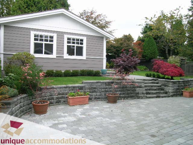 Furnished 4-bedroom house with stone steps, potted plants, and a brick patio. - 1365 Kings Ave, West Vancouver
