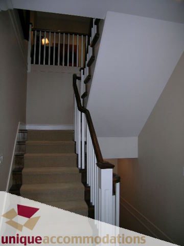 Staircase leading to upper floor with white railings and carpeted steps. - 1365 Kings Ave, West Vancouver