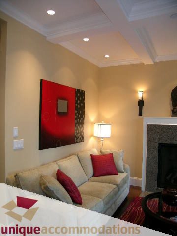 Furnished living room with coffered ceiling, red artwork, and beige couches. - 1365 Kings Ave, West Vancouver
