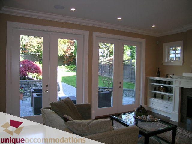 Living room with large windows, fireplace, and comfortable seating. - 1365 Kings Ave, West Vancouver