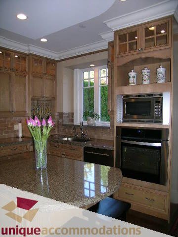 Bright kitchen with granite countertops, wooden cabinets, and a window view. - 1365 Kings Ave, West Vancouver