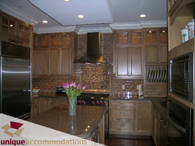 Bright kitchen with granite countertops, stainless steel appliances, and wooden cabinets. - 1365 Kings Ave, West Vancouver