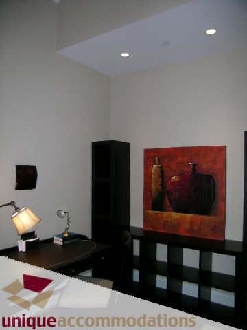 Modern office with sleek black countertops and contemporary artwork. - 1365 Kings Ave, West Vancouver