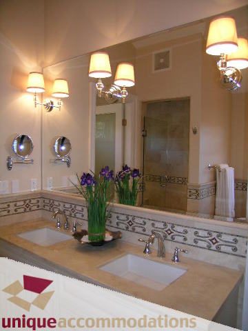 Bathroom with dual sinks, decorative countertop, and wall sconces. - 1365 Kings Ave, West Vancouver