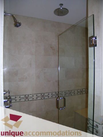 Shower with glass door and tiled walls. - 1365 Kings Ave, West Vancouver