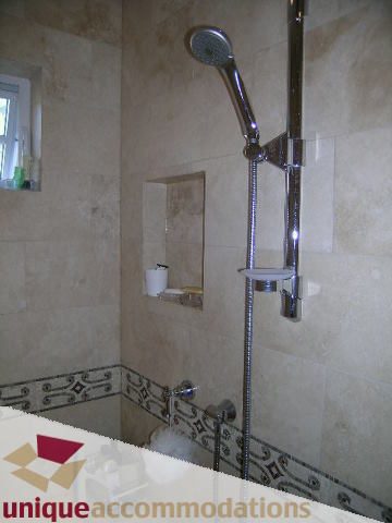Bathroom with modern shower and beige tiles. - 1365 Kings Ave, West Vancouver