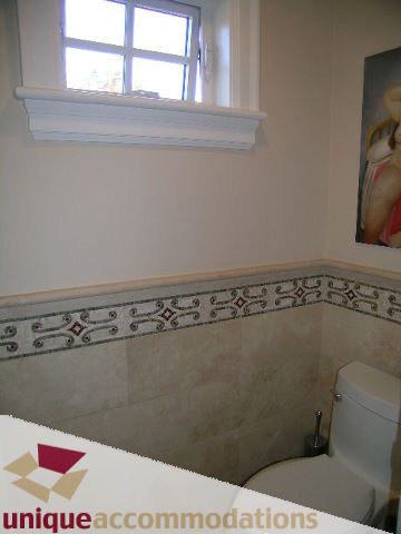 Bathroom with decorative tile border and toilet. - 1365 Kings Ave, West Vancouver