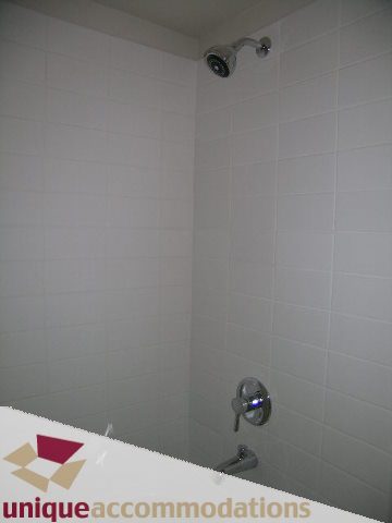 Bright bathroom with white tiles and modern showerhead. - 201 - 1133 Homer Street, Vancouver Downtown