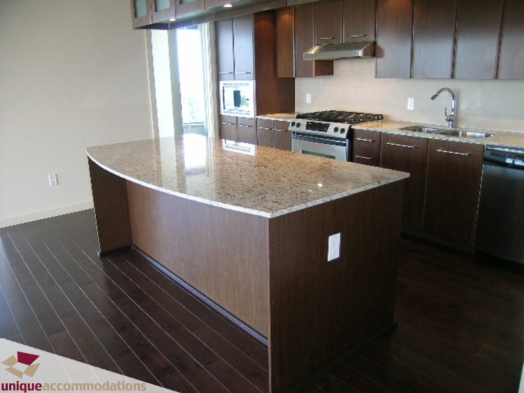Bright kitchen with granite countertops, dark hardwood floors, and a city view. - 905 - 683 Victoria Park West, North Vancouver