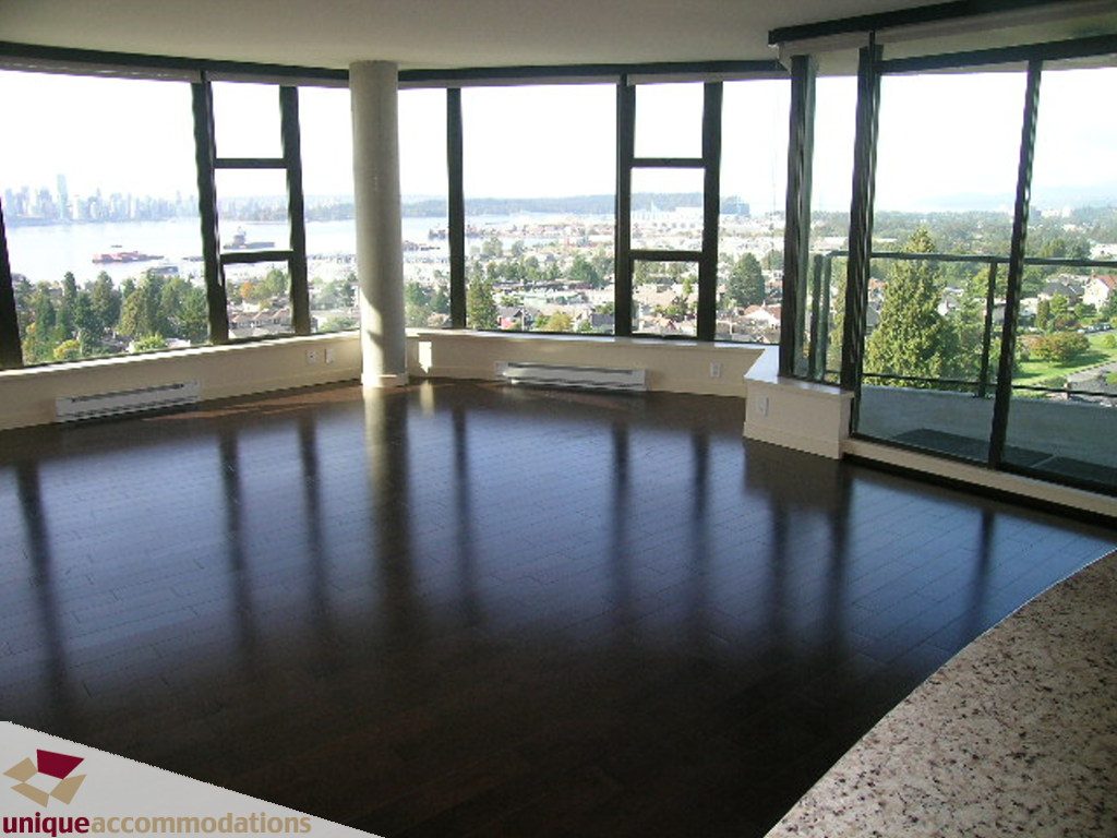 Bright living room with hardwood floors and a stunning city view. - 905 - 683 Victoria Park West, North Vancouver