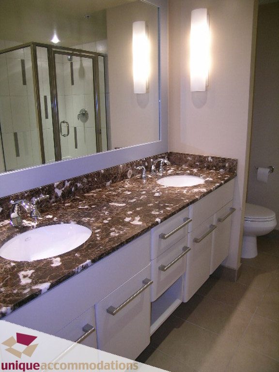 Bathroom with double vanity, granite countertop, and modern lighting. - 905 - 683 Victoria Park West, North Vancouver