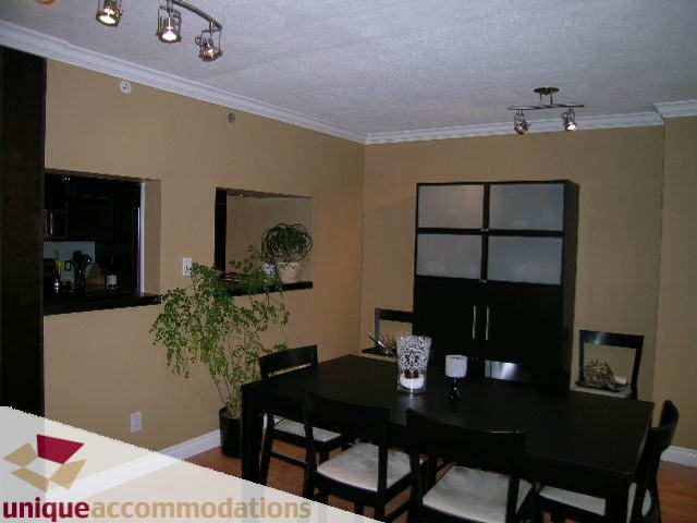 Furnished dining area with black table, chairs, and modern shelving; plants add greenery. - 2803 - 930 Cambie Street, Vancouver Downtown