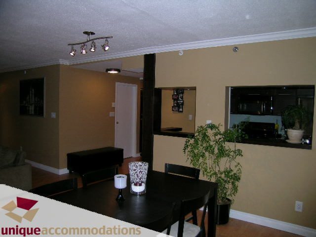 Furnished dining area with dark wood table, potted plants, and modern lighting. - 2803 - 930 Cambie Street, Vancouver Downtown