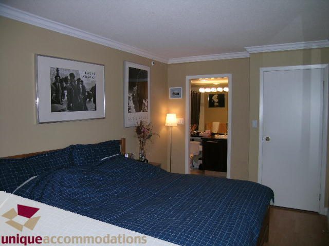 Furnished bedroom with two beds, blue bedding, and artwork on the walls. - 2803 - 930 Cambie Street, Vancouver Downtown
