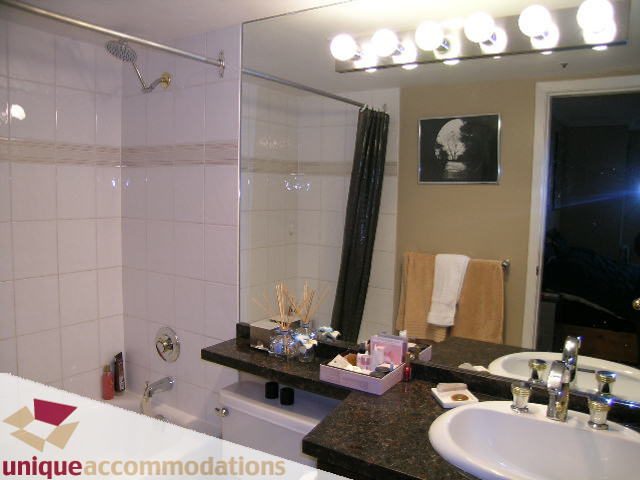 Furnished bathroom with granite countertops and a large mirror. - 2803 - 930 Cambie Street, Vancouver Downtown