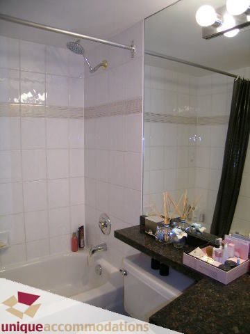 Furnished bathroom with white tiles, modern shower, and granite countertop. - 2803 - 930 Cambie Street, Vancouver Downtown