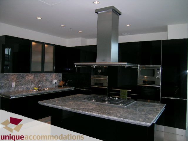 Bright kitchen with black cabinets, granite countertops, and stainless steel appliances. - 104 - 1139 West Cordova Street, Vancouver Downtown