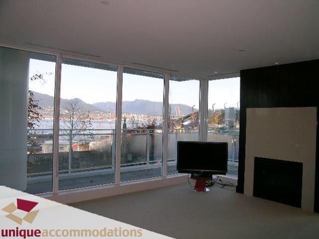 Spacious living room with large windows, city view, and modern furnishings. - 104 - 1139 West Cordova Street, Vancouver Downtown
