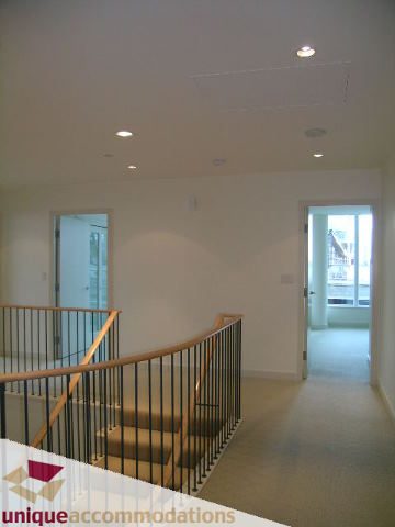 Bright and airy living room with a view of the city and a staircase leading to the upper level. - 104 - 1139 West Cordova Street, Vancouver Downtown