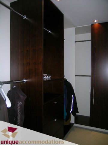 Furnished walk-in closet with dark wood paneling and hanging space. - 104 - 1139 West Cordova Street, Vancouver Downtown