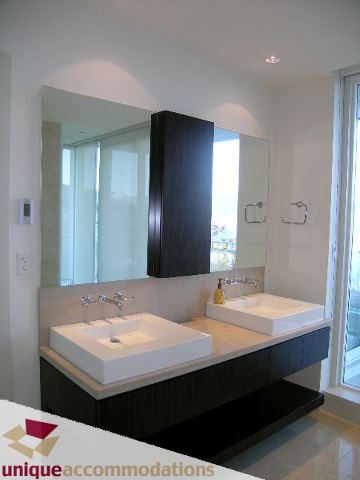 Modern bathroom with dual sinks, large mirror, and dark wood cabinets. - 104 - 1139 West Cordova Street, Vancouver Downtown