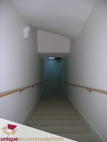 Staircase leading to upper level with carpeted steps and wooden handrails. - 104 - 1139 West Cordova Street, Vancouver Downtown
